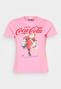 Rosa bomulls t-skjorte med en vintage Coca-Cola grafikk av julenissen og et rådyr, med rød tekst og detaljer. Korte ermer og rund hals.