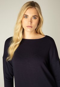 Langarmshirt in marineblauw, gemaakt van zachte stof. Kenmerkt zich door een brede ronde halslijn en een relaxed fit, met subtiele stiksels.
