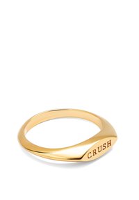 Anillo de oro con una banda lisa y redondeada y un detalle grabado de "CRUSH" en un lado. El diseño es elegante y minimalista.