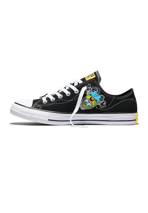 Sneaker nera low-top con suola e lacci bianchi, con un allegro personaggio minion dei cartoni animati sul lato e dettagli di branding gialli.