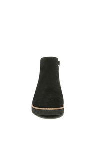 Schwarze Wildleder-Ankle-Boots mit runder Spitze, einem seitlichen Reißverschluss und einer kontrastierenden hellbraunen Sohle. Glatte Textur und elegantes Design.