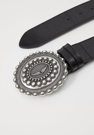Black leather belt featuring an oval silver-tone buckle with raised dots and an engraved central pattern. Smooth texture with a classic design.