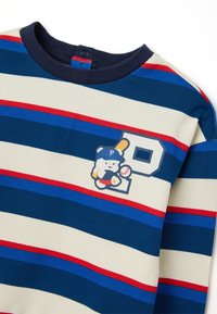 Camicia di cotone a maniche lunghe con righe orizzontali in navy, crema e rosso. Presenta una grafica di un orso con una pallina da baseball e la lettera "P."