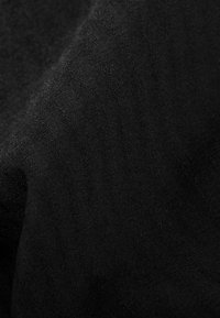 Black textile featuring a fine, smooth texture with subtle sheen and intricate patterns, demonstrating a lightweight and versatile material.