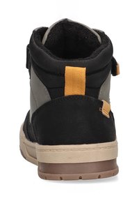 Botín acolchado en negro y gris con una suela de goma marrón y una lengüeta amarilla en la parte trasera. Presenta un interior con forro suave.