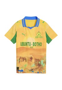 Camiseta de fútbol amarilla de manga corta con acentos verdes y un cuello azul. Presenta patrones abstractos del desierto y el texto "UBUNTU-BOTHO" en verde.