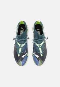 Scarpe da atletica Puma con tomaia in mesh, caratterizzate da strisce diagonali blu, verdi e nere, punta rotonda e lacci a contrasto.