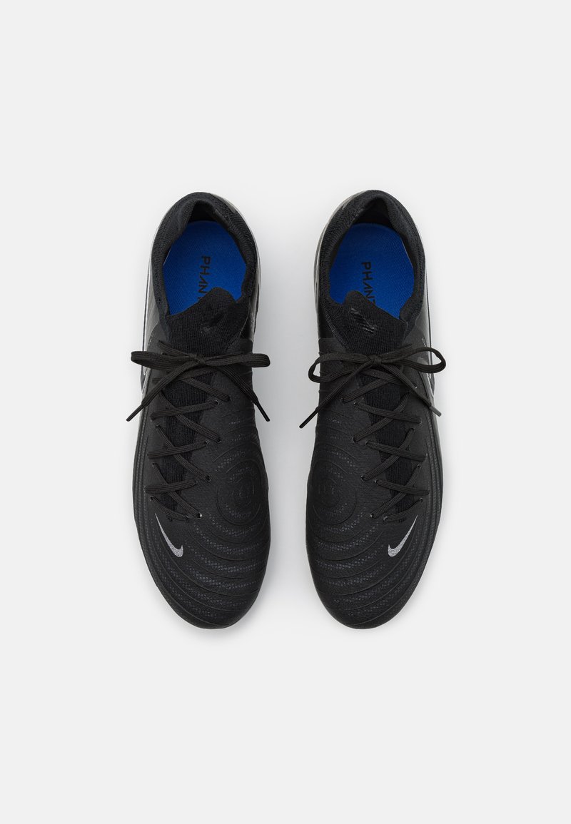 Zapatillas deportivas negras con superficie texturizada, patrones redondeados, cordones negros y plantillas azules. Presentan un pequeño logo plateado en el costado.