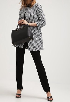Black and white checkered coat with three-quarter sleeves, black top, and black pants. Black handbag with gold accents and platform sandals.