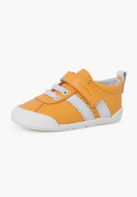 Sneaker giallo in pelle con strisce bianche, lacci elastici e una fascia in Velcro. Suola in gomma testurizzata e un'imbottitura morbida per il comfort.