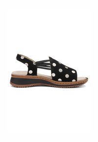 Černá sandála s otevřenou špičkou a bílými puntíky, elastickými bočními pásky, polstrovanou stélkou a texturovanou hnědou a černou podrážkou.