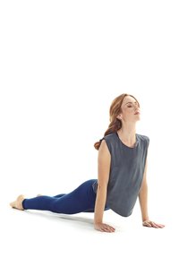 Gray sleeveless top, blue leggings, woman performing a yoga pose on a white background. Smooth fabric, relaxed fit, arms extended forward.