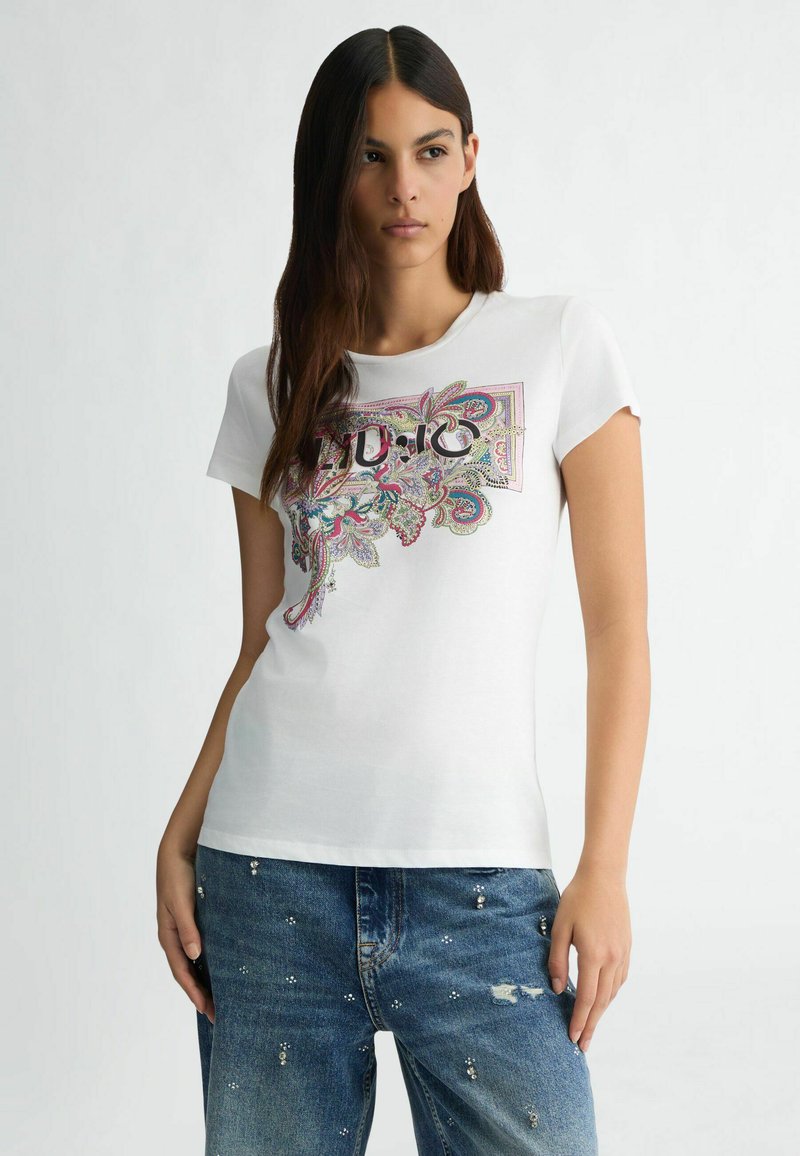 T-shirt bianca in cotone con un elaborato design floreale e paisley colorato nella parte anteriore, maniche corte e scollatura rotonda.