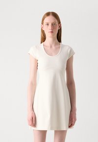Crème-kleurige jurk met korte mouwen, ronde halslijn, getailleerde bovenkant en uitlopende rok vanaf de taille. Glad, lichtgewicht stof met minimale naden.