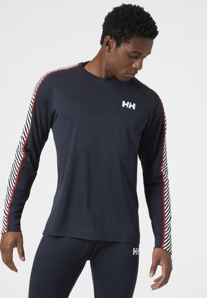 Marineblauwe sportshirt met lange mouwen, voorzien van rode en witte gestreepte accenten op de mouwen. Heeft een logo op de borst en een zachte, gestructureerde stof.