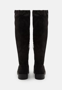 Svarta mocka knähöga stövlar med slät textur, rundad tå, låg klack och dekorativa blixtlås på sidan.