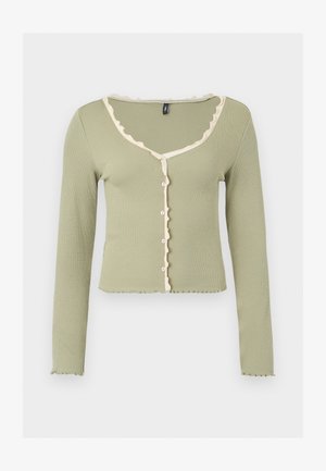 Heledat rohelise kerge soonikkoega pikkade varrukatega kardigan, millel on valge volangidega ääris kaeluse, nööpideesise ja varrukaotste ümber, esiküljel nööpidega kinnitatav.