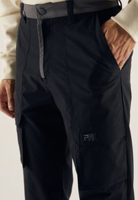 Svarta cargobyxor med en slät textur, med en grå midja och logopatch. Inkluderar sidofickor och en rak benklippning.
