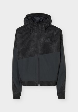 Sort hættejakke med gråt diagonalt panel og gittermønster, fuld lynlås foran og Adidas-logo på brystet.