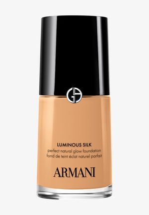 Botella de cristal de la base Armani Luminous Silk con tapa negra y logo, tono beige, etiquetada como "base de brillo natural perfecto".