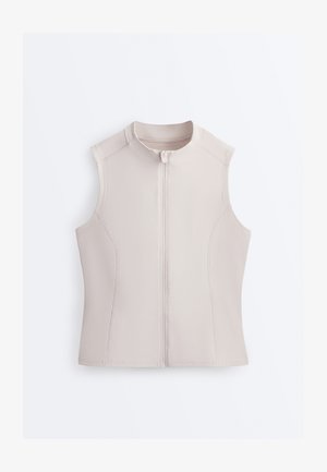 Brezrokavnik bež barve z zadrgo spredaj in okroglim izrezom, oprijet kroj s ukrivljenimi šivi.