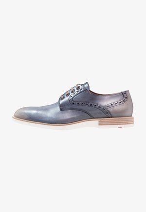 Chaussure habillée en cuir gris avec détails perforés, bout arrondi et semelle beige. Comprend des lacets marron et un design minimaliste.