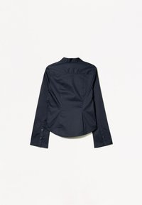 Granatowa koszula z długim rękawem, z kołnierzykiem w szpic, plisami z tyłu i zapinanymi na guziki mankietami. Wykonana z gładkiego materiału, o dopasowanym kroju.