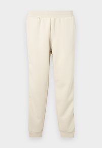Pantalons de survêtement beige clair fabriqués en tissu doux avec un design fuselé, une ceinture élastique et des poignets aux chevilles. Pas de motifs ou d'accents visibles.