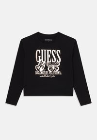 Black long-sleeve crop top made of organic cotton, featuring white graphic text and butterfly designs, with a crew neckline.