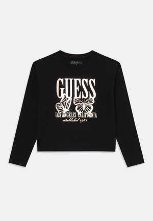 Crop top noir à manches longues en coton organique, avec des textes graphiques blancs et des motifs de papillons, doté d'un col rond.