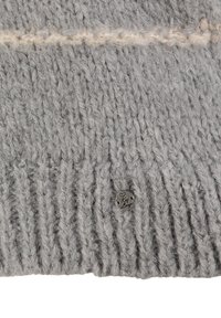 Grau gestrickte Mütze mit gerippter Textur, ausgestattet mit einem cremefarbenen horizontalen Stickdetail und einem kleinen runden Metalllogo.