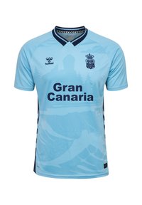 Lyseblå fodboldtrøje med teksten "Gran Canaria", mørkeblå krave og logoer, samt et subtilt landskabsdesign med bjerge og træer.