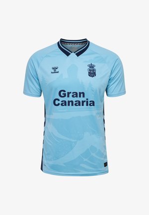 Maillot de soccer bleu clair avec le texte "Gran Canaria", col marine foncé et logos, et un design subtil de paysage de montagnes et d'arbres.