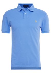 Ljusblå pikétröja i texturerad bomull. Har en klassisk krage, två knappar och en gul broderad logotyp på bröstet.