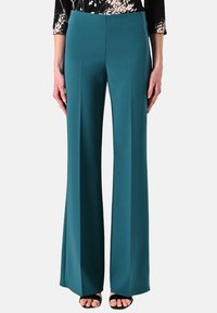 Teal wijde broek gemaakt van gladde stof, met een platte voorkant, zijplooien en een hoge taille, gecombineerd met zwarte sandalen.