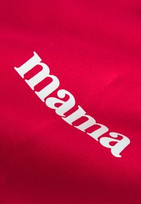 Röd tyg med strukturerad yta, med ordet "mama" i stora vita bokstäver, placerat diagonalt över materialet.