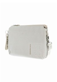 Sac bandoulière en tissu blanc avec une surface texturée, une quincaillerie argentée, une fermeture éclair et une sangle amovible. Nom de la marque embossé à l'avant.