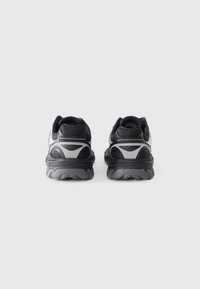Black and gray athletic shoes with a mesh upper, padded collar, and a textured rubber sole, featuring reflective accents on the sides.