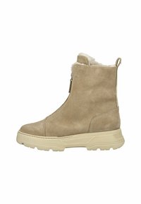 Botines de ante beige con un suave forro de piel, cierre lateral con cremallera y una suela de goma ligera en contraste con detalles texturizados.
