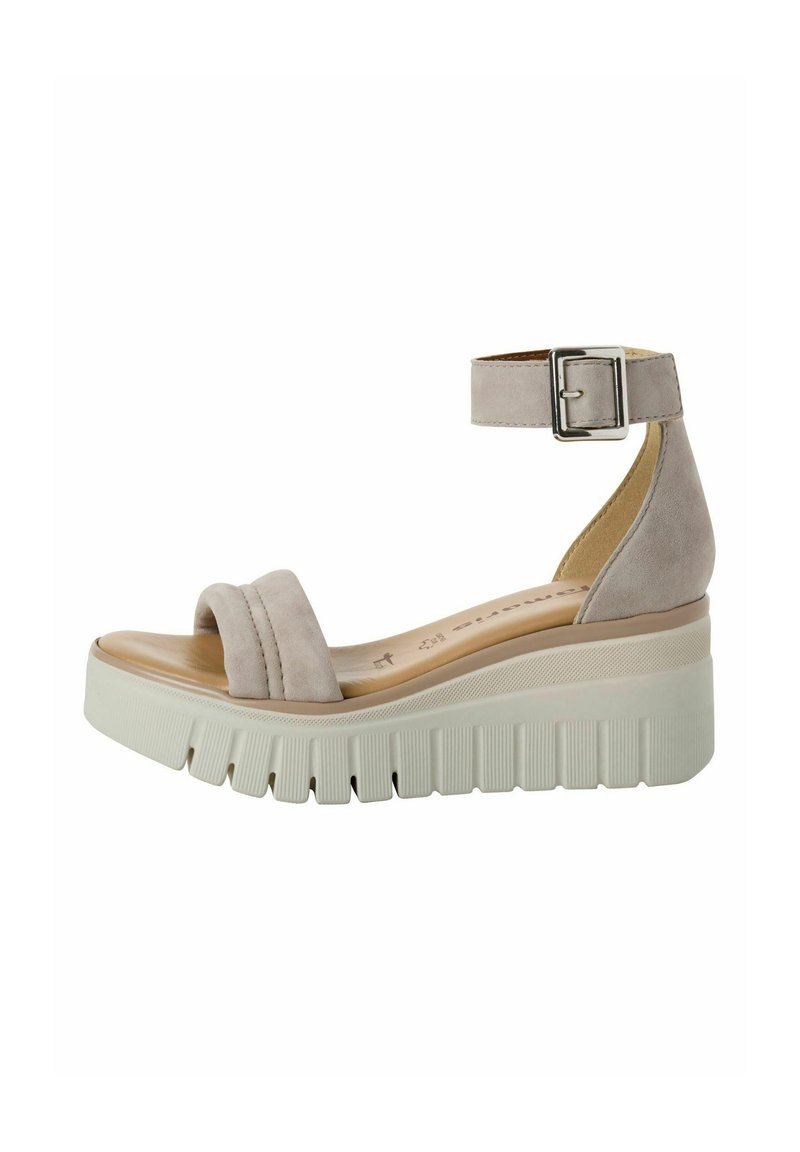 Sandalo wedge in suede beige con doppie cinghie frontali, fibbia alla caviglia e piattaforma testurizzata. Presenta una suola robusta e scanalata per maggiore stabilità.