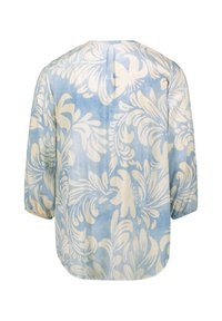 Blusa azzurro chiaro con grande stampa floreale bianca, tessuto morbido, maniche a tre quarti, orlo arrotondato e delicate pieghe sul retro.