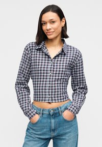 Κοντοκομμένο πουκάμισο με μακριά μανίκια σε καρό μοτίβο με ναυτικό μπλε, κόκκινο και λευκό. Κατασκευασμένο από υφαντό ύφασμα με κουμπιά μπροστά και γιακά.