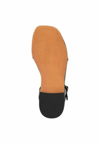 Sandalia negra con un diseño de tira único, que presenta una base de goma plana y una suela de tono marrón suave con un acabado texturizado.