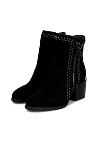 Botas de tobillo de ante negro con un tacón grueso, cierre de cremallera y acentos de tachuelas a lo largo de los lados para un detalle adicional.