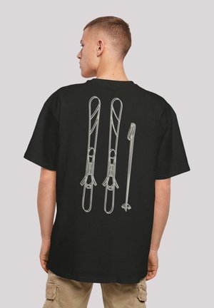 Black t-shirt with a white graphic design featuring two skis and a ski pole on the back. Short sleeves, relaxed fit, made of cotton.