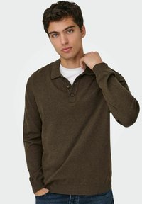 Maglione polo verde scuro a maniche lunghe in tessuto morbido, con collo a polo, abbottonatura a due bottoni e polsini e orlo a coste.