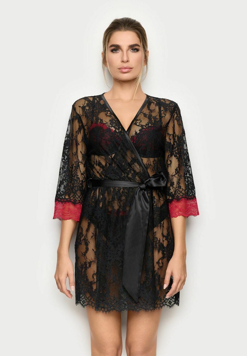 Černý krajkový župan s červeným krajkovým lemem na rukávech. Obsahuje černý saténový pásek a průhledný design, který zvýrazňuje složité květinové vzory.