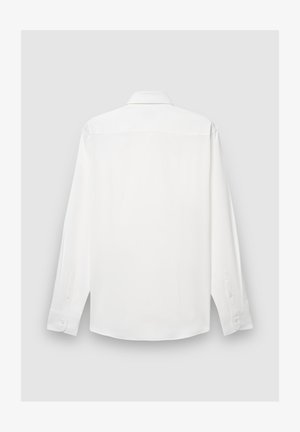 Chemise blanche à manches longues en tissu lisse, avec un col classique, des poignets boutonnés et un ourlet droit sans poches ni motifs.