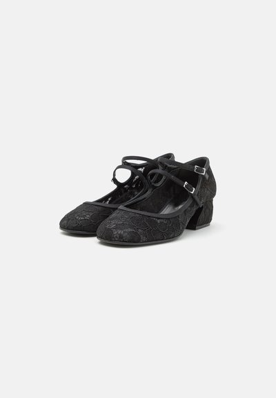 Black heeled shoes with a textured lace overlay, featuring a rounded toe, ankle straps, and a sturdy, low block heel.