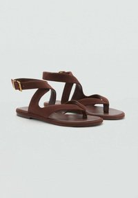 Bruine platte sandalen met een tegendesign, enkelband en gouden gesp. Gemaakt van glad materiaal met een minimalistische vorm en afwerking.
